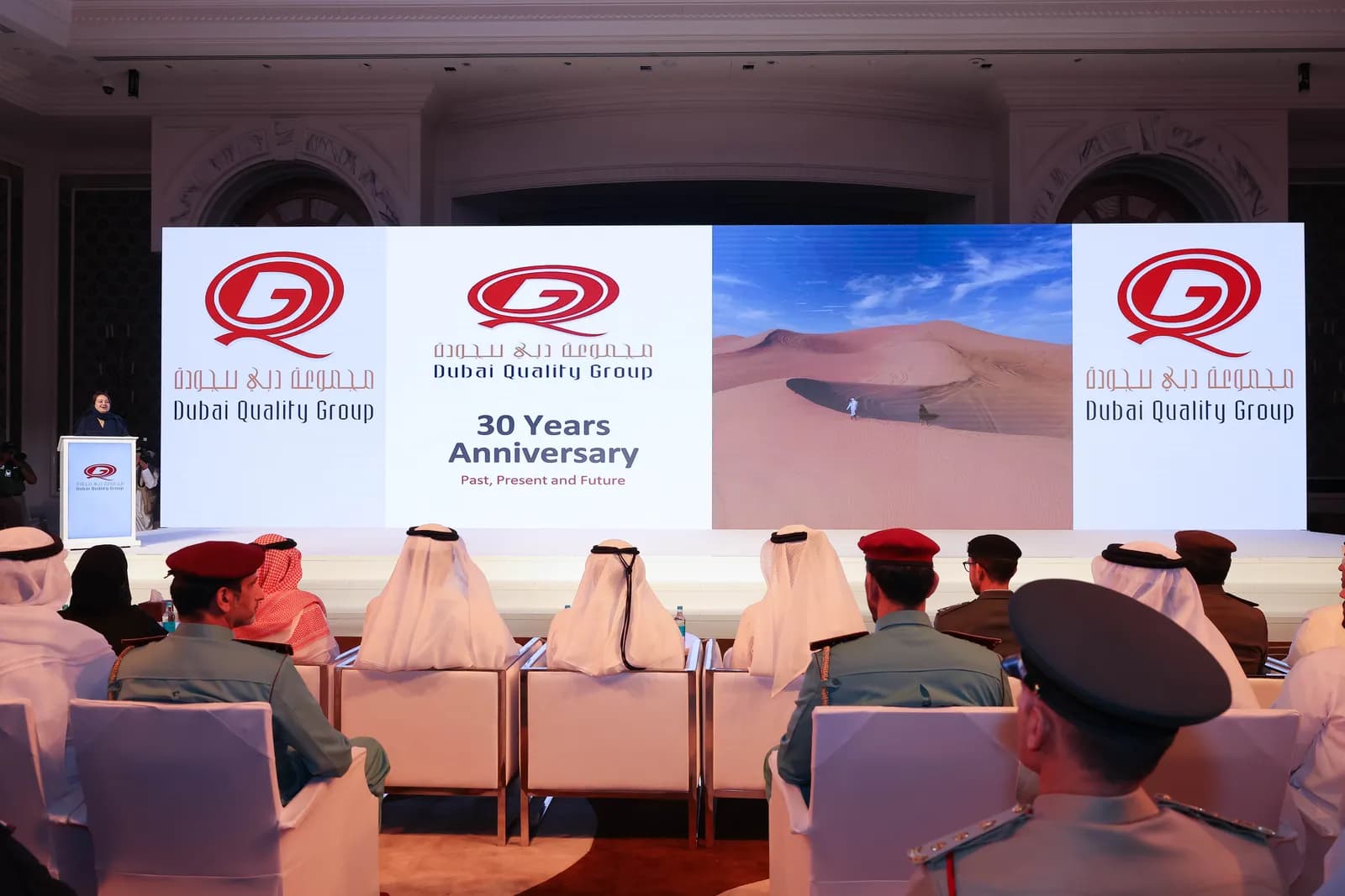 Audience in front of a stage banner reading Dubai Quality Group 30 Years Anniversary